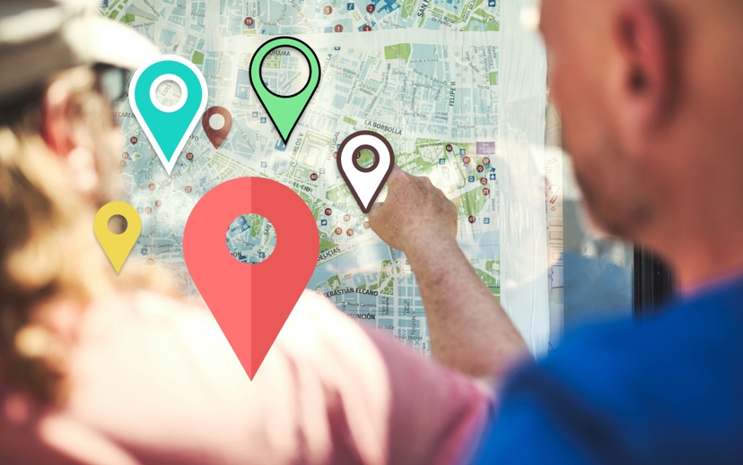 Zwei ältere Männer stehen vor einer Wanderkarte, über die Location Marker gelegt sind