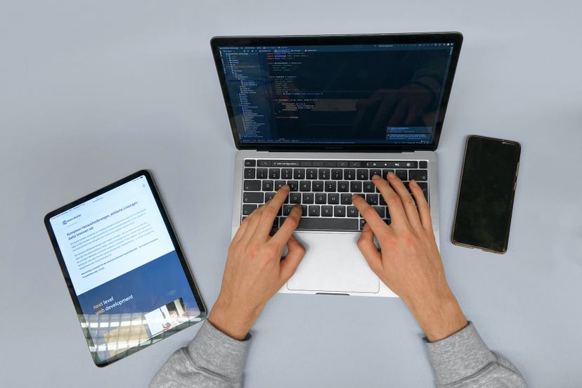 Entwickler tippt auf Macbook, iPad, und iPhone