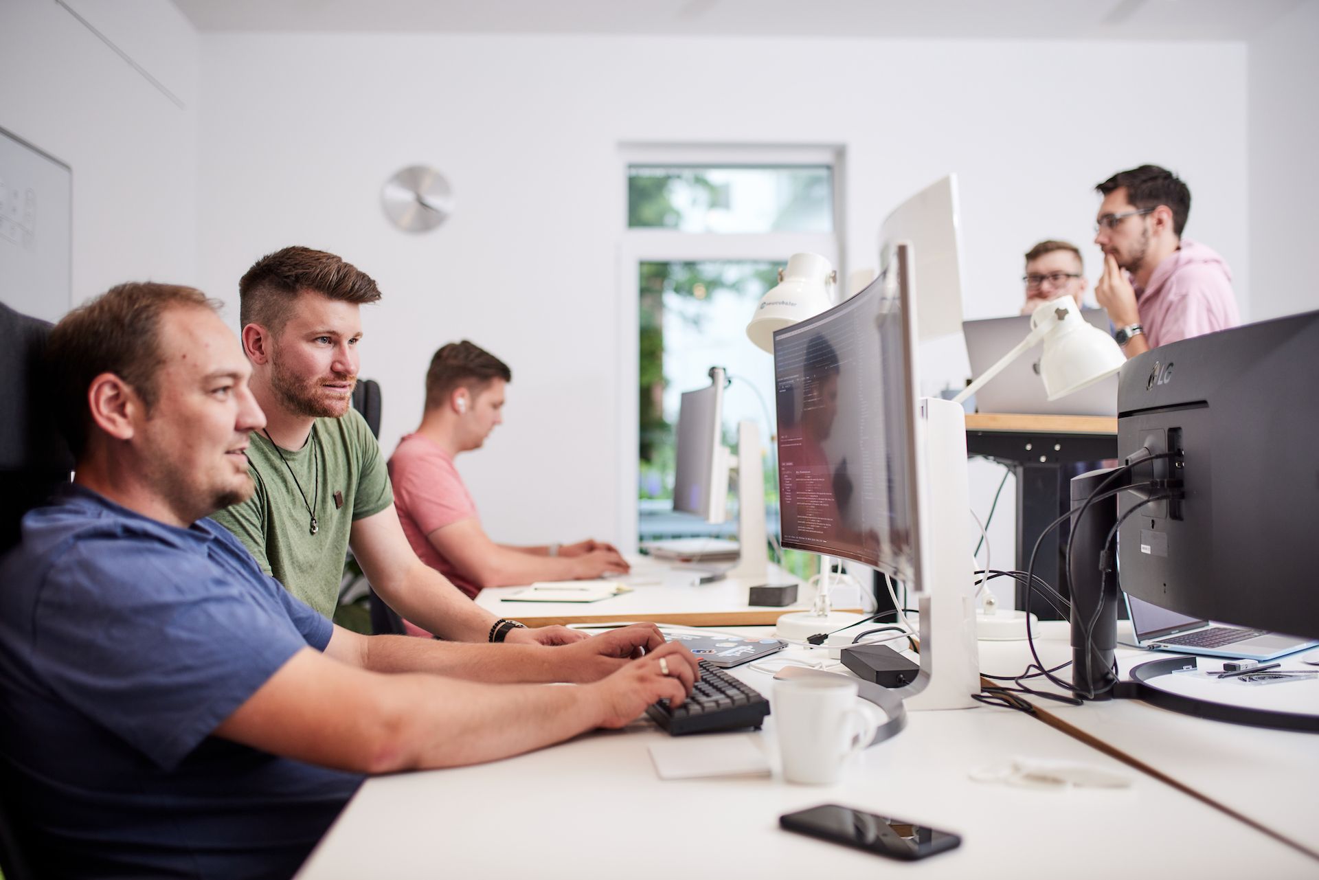 Zwei Kollegen schauen zusammen auf einen Monitor