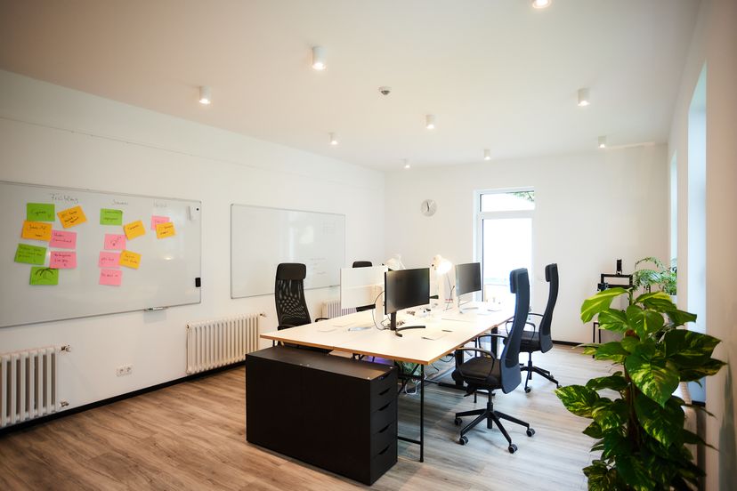 Ein Büroraum mit zwei Whiteboards an der Wand. An einem Whiteboard hängen bunte Post its, die gruppiert und sortiert sind.
