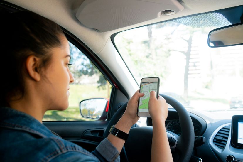 Eine junge Frau nutzt ihr Handy um per Karte zu navigieren